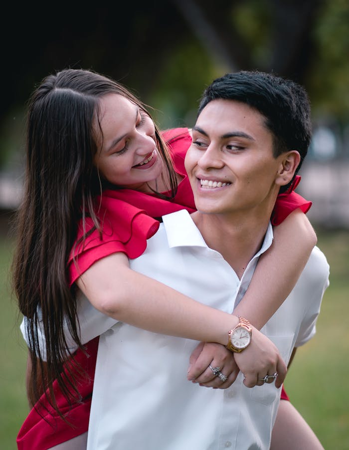 hero-gallery-04 Young couple enjoying a playful piggyback ride in a park setting.